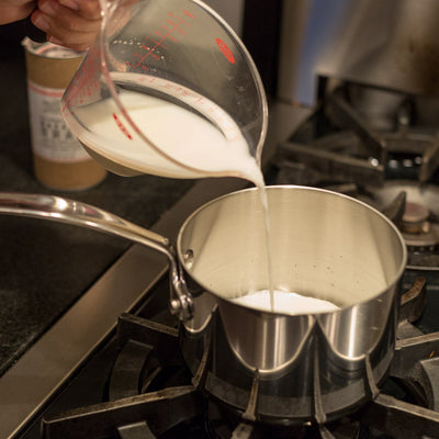 Bollywood Theater Masala Chai Tea preparation, add whole milk to saucepan