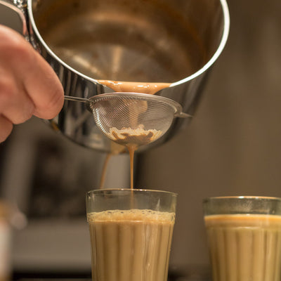 Strain Bollywood Theater Masala Chai Tea into glass with a strainer